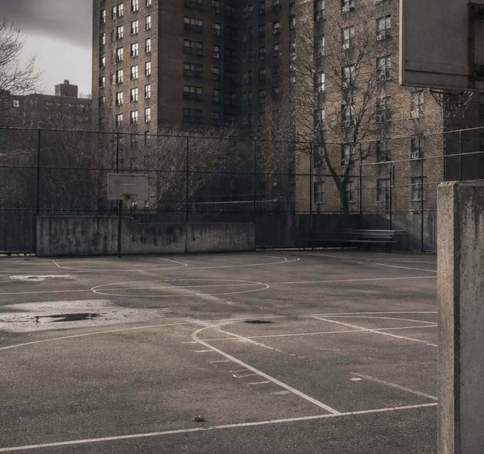 A Queens school basketball court surrounded by chain-link fencing